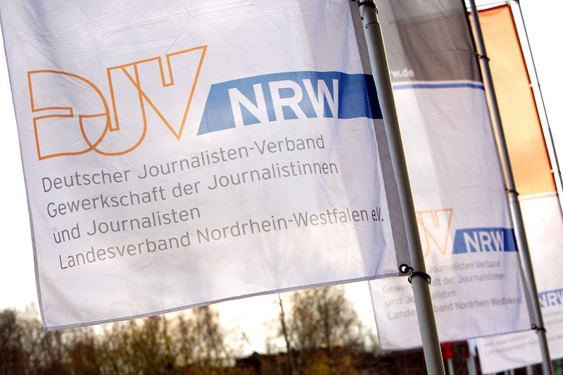 Vor dem Eingang des Journalistentages wehen weiße Fahnen mit dem Logo des DJV-NRW