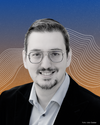 Ein Portraitbild von Pascal Hesse vor orange-blauen Hintergrund. – 