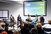 5 Frauen sitzen im Panel auf der Bühne und diskutieren über Sexismuserfahrungen im Beruf. – 